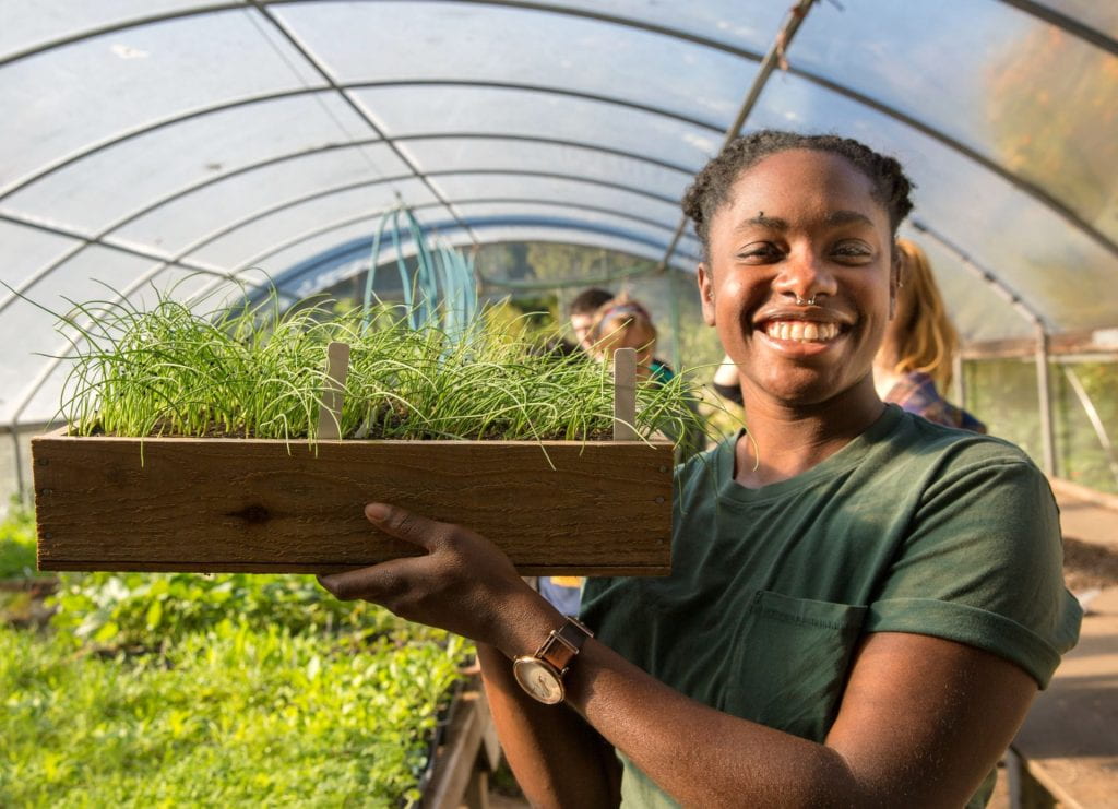student with box of seedlings