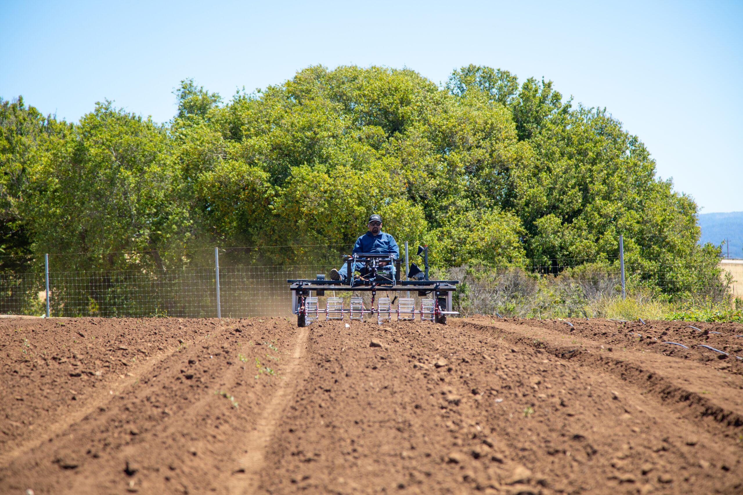 person on tilling machine at UCSC farm
