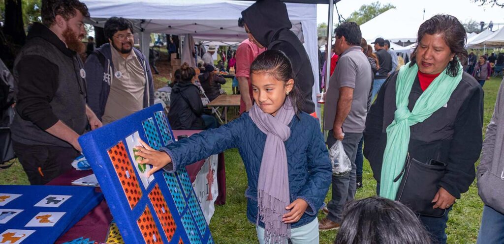 Kid at linguistic booth at an event touching a presentation.
